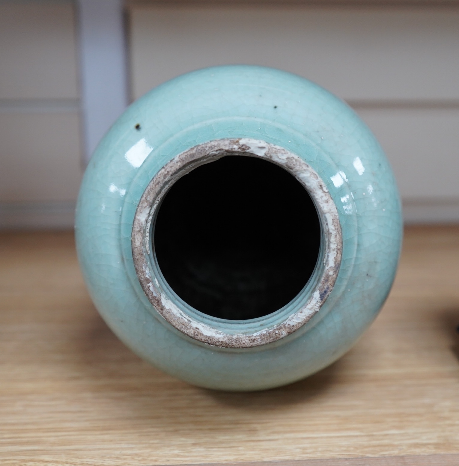 A 17th century Chinese celadon crackle glazed vase, 29cm. Condition - ground down
